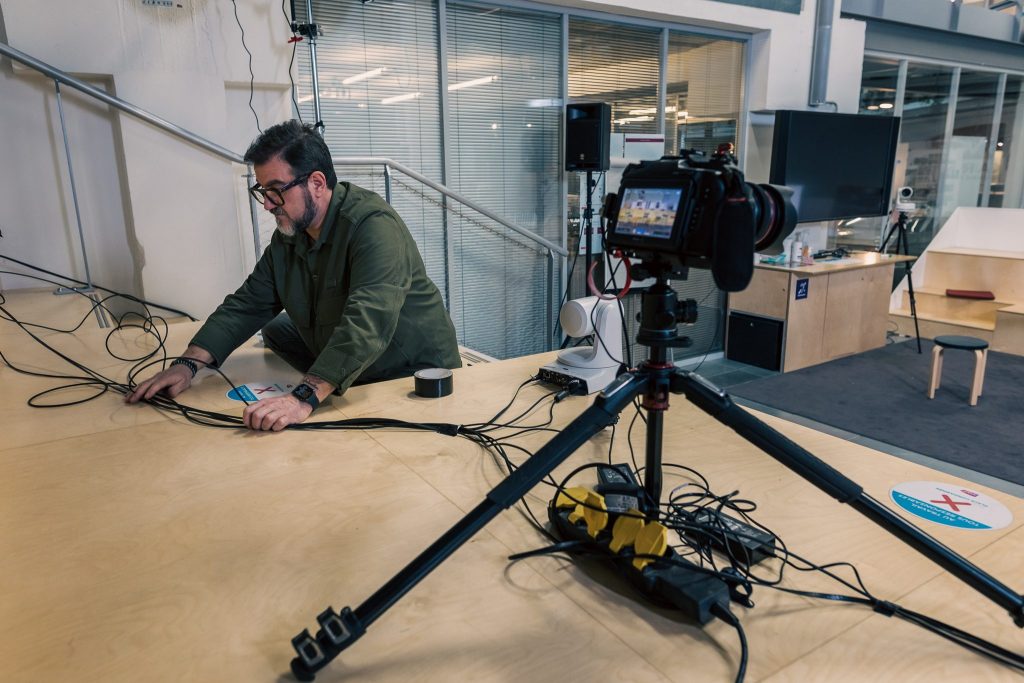 Photo des coulisses d’une captation vidéo : technicien installant câbles et caméras pour un tournage ou un livestream professionnel.