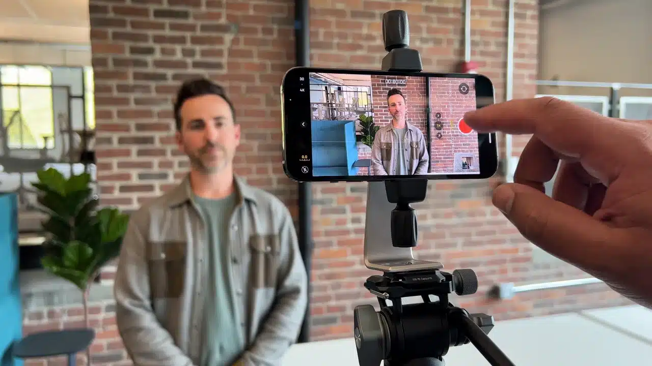 iPhone sur trépied filmant une interview d’un intervenant dans un bureau professionnel en brique