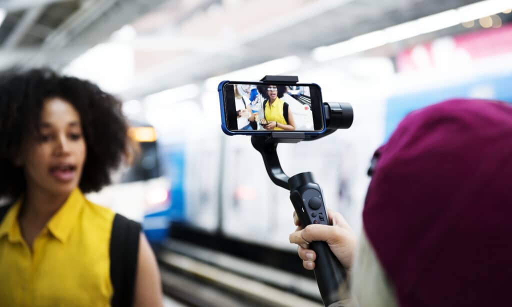 Personne filmant une interview à l’iPhone avec un stabilisateur dans une station de métro