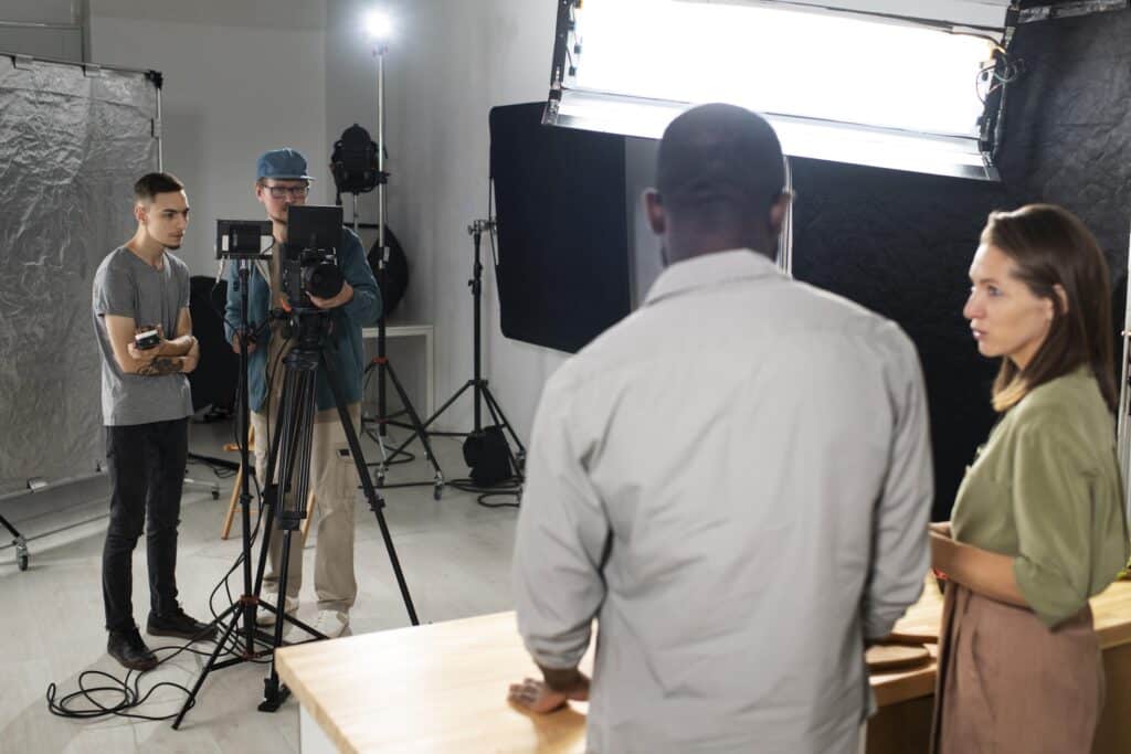 Équipe de tournage filmant une interview vidéo d'entreprise en studio avec caméra et éclairage professionnel